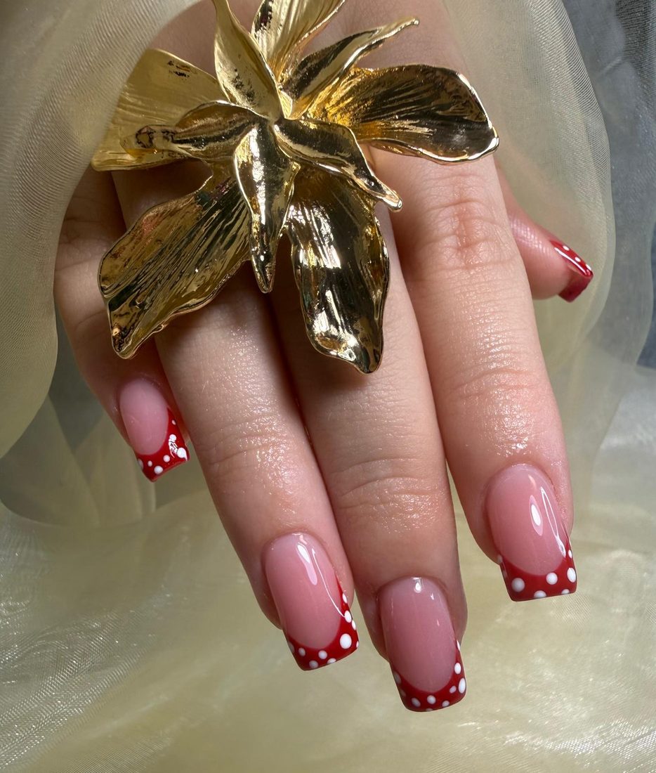Uñas francesas rojas con puntos y diseño de flor - salón de uñas Tampa
