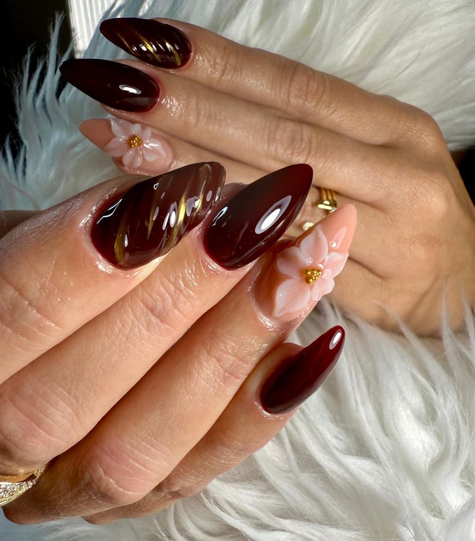Uñas vino almendra con detalles dorados y flor 3D blanca